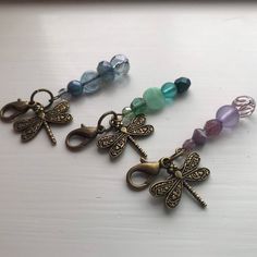 three dragonfly charms are sitting on a table