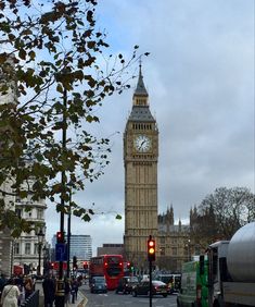 the big ben clock tower towering over the city of london, england as traffic passes by