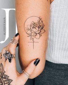 a woman's leg with a flower tattoo on it and a cross in the middle