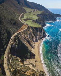 an aerial view of the ocean and coastline with a highway running along it's sides