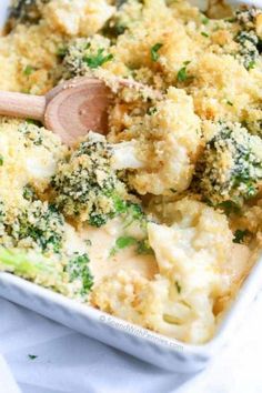 broccoli and cauliflower casserole in a white dish with a wooden spoon