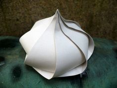 an origami sculpture sitting on top of a green cushion