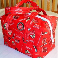 a coca cola bag sitting on top of a bed