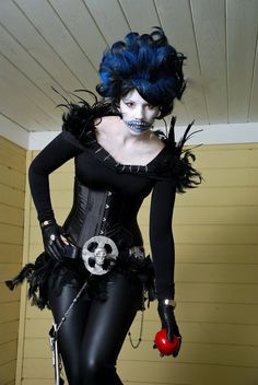 a woman with blue hair and makeup is dressed in black