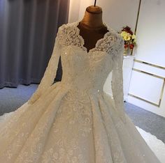 a white wedding dress with long sleeves on display