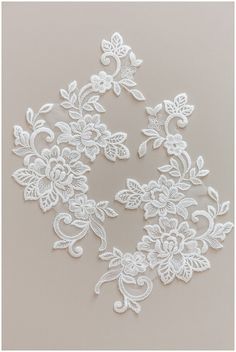 white lace with flowers and leaves is shown on a gray background, as well as the word