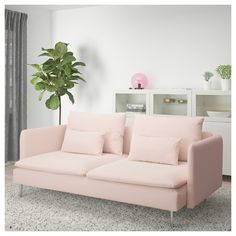 a white couch sitting in a living room on top of a carpeted floor next to a window