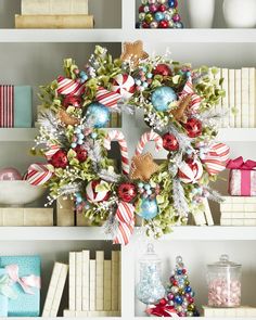 a christmas wreath sitting on top of a bookshelf next to other holiday decorations