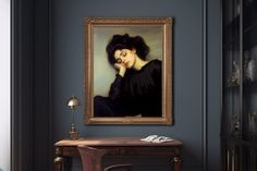 a painting hanging on the wall next to a desk and chair in a room with blue walls