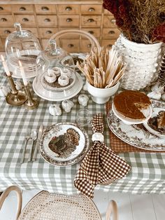 the table is set with dishes and desserts