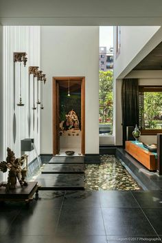 an open door leading to a living room filled with furniture and artwork on the walls