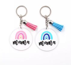 two key chains with the words mama and rainbows on them, one has a tassel