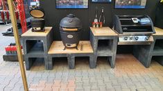 an outdoor bbq grill with two side tables