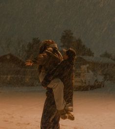 two people are walking in the snow with an umbrella over their heads and one is carrying another person