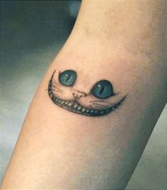 a close up of a person's leg with a cat tattoo on the ankle