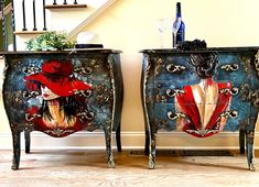 two side tables with painted designs on them next to a stair case and glass vase