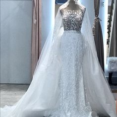 a white wedding dress on display in front of a mannequin's head