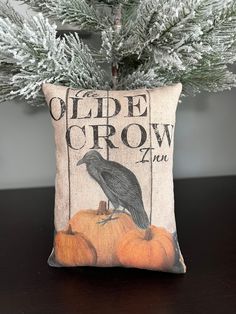 a pillow with a crow sitting on top of pumpkins