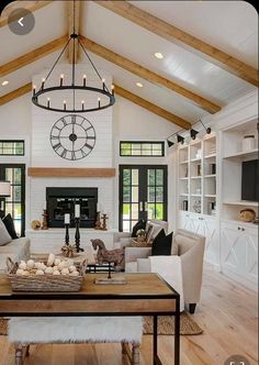 a living room filled with furniture and a large clock mounted to the wall above it