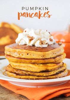 a stack of pumpkin pancakes with whipped cream on top and the words pumpkin pancakes above it