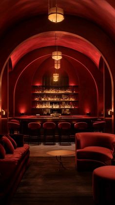 a dimly lit room with red couches and bar in the backgrounge