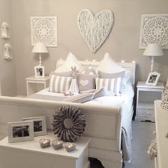 a bedroom with white furniture and pictures on the wall, along with other decor items