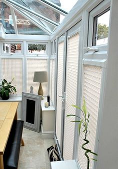 a room filled with lots of windows next to a wooden table