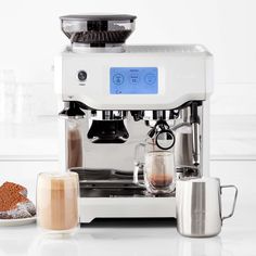 an espresso machine sitting on top of a counter next to a cup of coffee