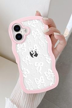 a woman holding an iphone case with white and pink designs on it's back