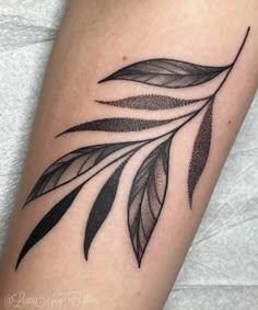 a black and white photo of a leaf tattoo