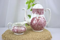 two red and white vases sitting next to each other on top of a table