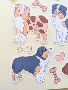 four different colored dogs stickers on a sheet of paper next to a cup of coffee