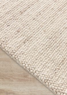 a white rug on top of a wooden floor with an area rug in the middle