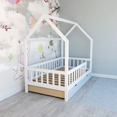 a white doll house bed in the corner of a room with wooden floors and wallpaper