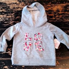 a child's hoodie with the word love printed on it