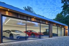 two sports cars are in the reflection of glass doors on this modern home's garage