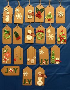 christmas tags with buttons and snowmen on them are hung on a blue tablecloth