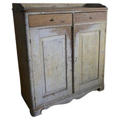 an old wooden cabinet with two doors and drawers