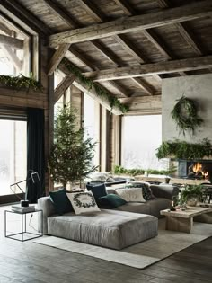 a living room filled with lots of furniture and christmas tree in the middle of it