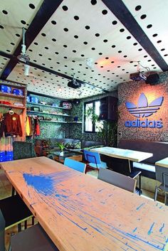 the inside of an adidas store with wooden tables and chairs