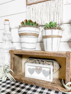 three potted plants sitting on top of a wooden shelf