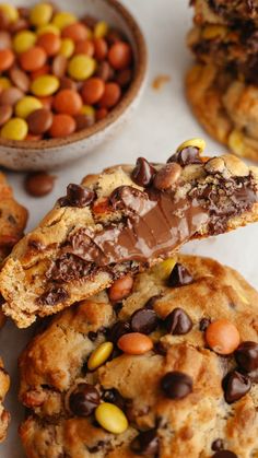 chocolate chip cookies with candy corn and oreo chips in the middle on a white surface