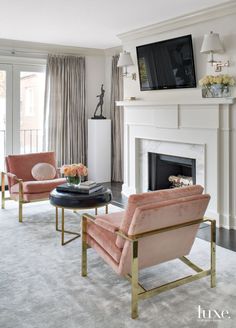 a living room filled with furniture and a fire place in front of a tv mounted on a wall