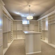 an empty walk in closet with white cabinets