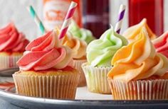 cupcakes with colorful frosting and candles on a plate