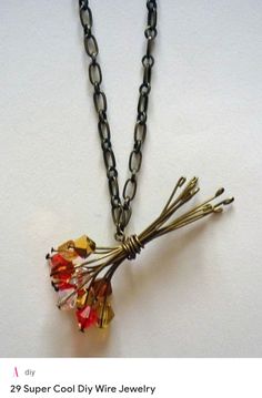 a necklace with flowers hanging from it's side on a white surface, in front of a chain