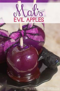 some purple apples are sitting on a black plate and the words mal's evil apples above them