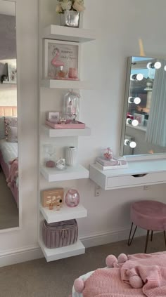 a room with a bed, mirror and pink chair in the corner next to it