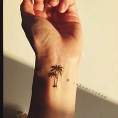 a small palm tree tattoo on the wrist