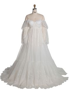 a white wedding gown on a mannequin headdress with long sleeves and ruffles